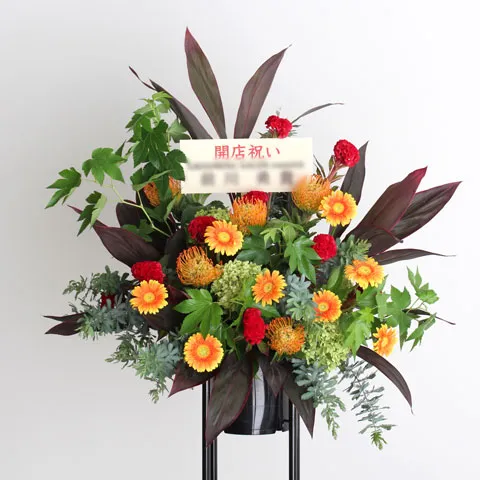 赤とオレンジの花が印象的な、開店祝いの花束