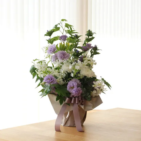 パステルカラーの紫と白の花々が、リボンで上品にまとめられた花束