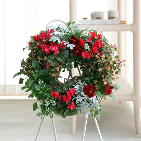 赤い花と緑の葉で作られた、ハンギングリース